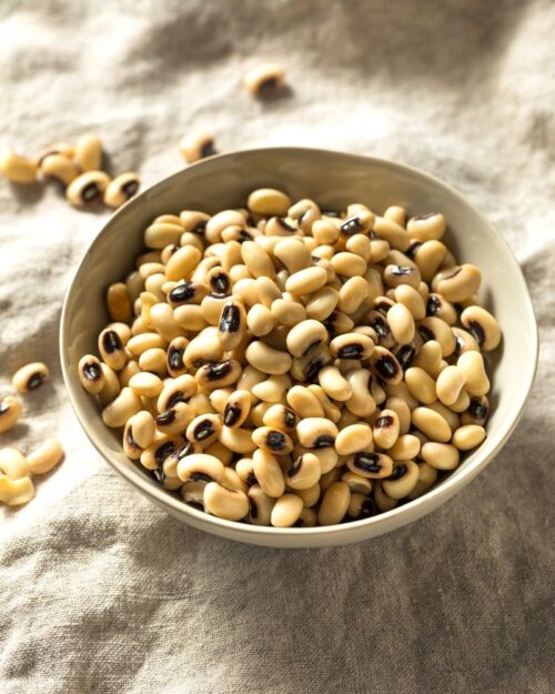 Uncooked black eyed peas in a white bowl. 