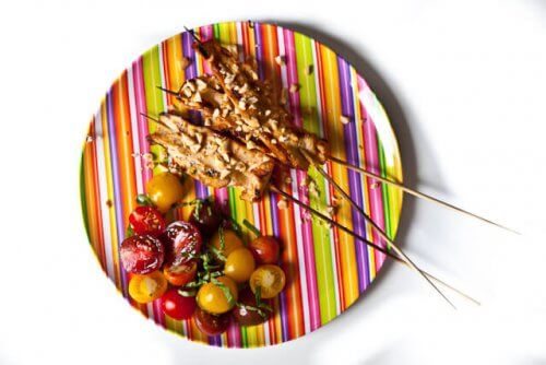 Chicken satay on a striped plate