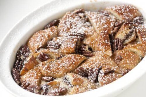 Nutella bread pudding in a white bowl with powdered sugar on top.