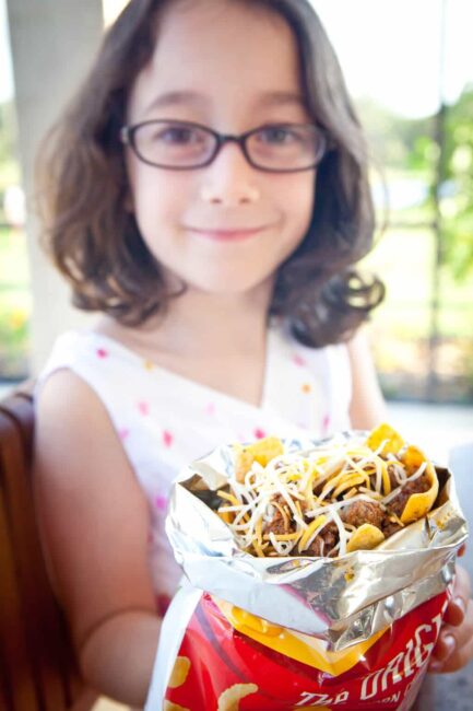 kid holding bag of frito pie