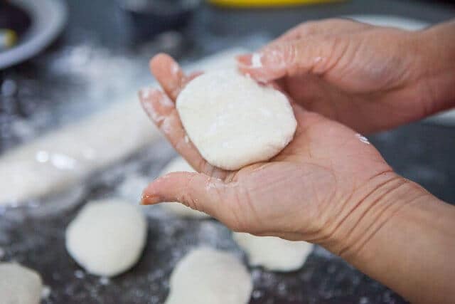 hand holding dough for chinese steamed buns