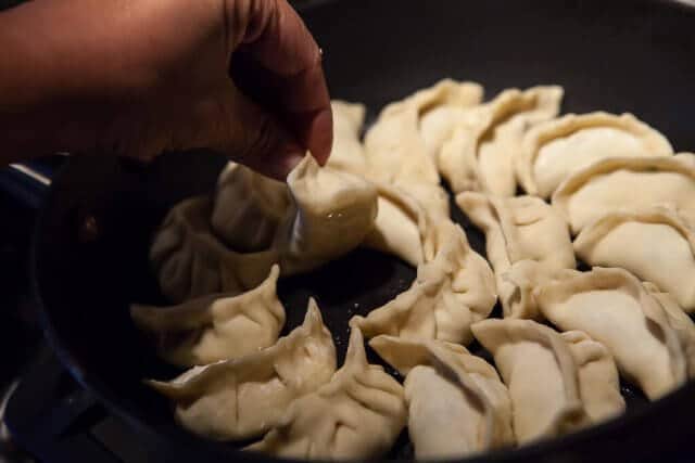 checking potsticker dumplings in pan