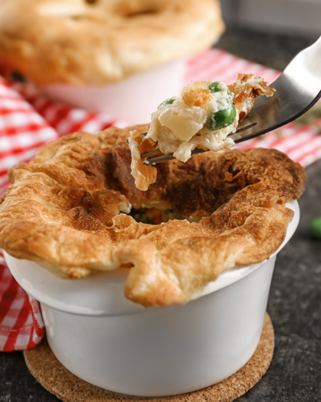Fork digging into a baked chicken pot pie. 