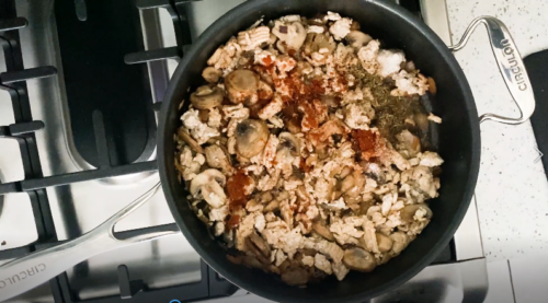 Seasoning healthy turkey stroganoff in the pan.