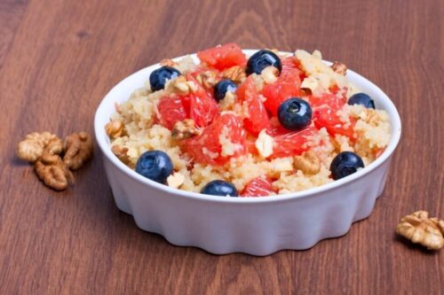 A bowl of couscous with blueberries and fruit