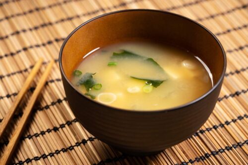 Miso soup in a bowl on a bamboo mat