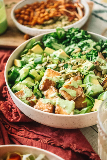 Green Goddess Tofu Bowl with drizzle of dressing in white bowl