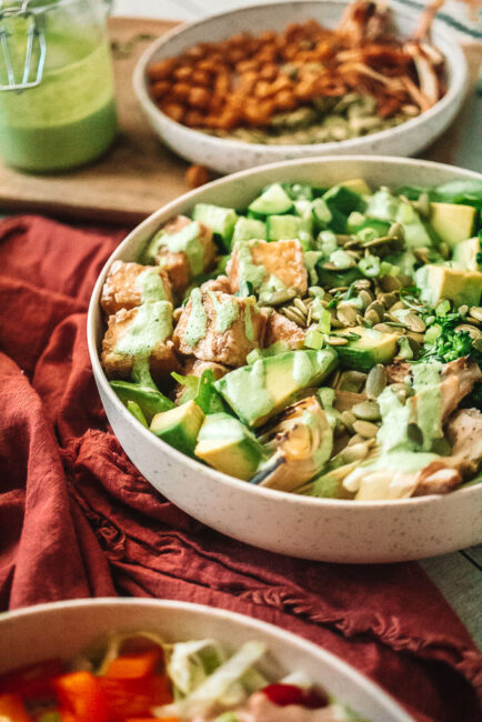 Green Goddess Tofu Bowl with drizzle of dressing in white bowl
