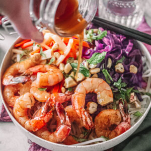 Vietnamese Shrimp Noodle Bowl with sauce in jar being poured over