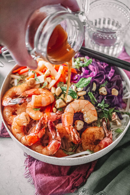 Vietnamese Shrimp Noodle Bowl with sauce in jar being poured over
