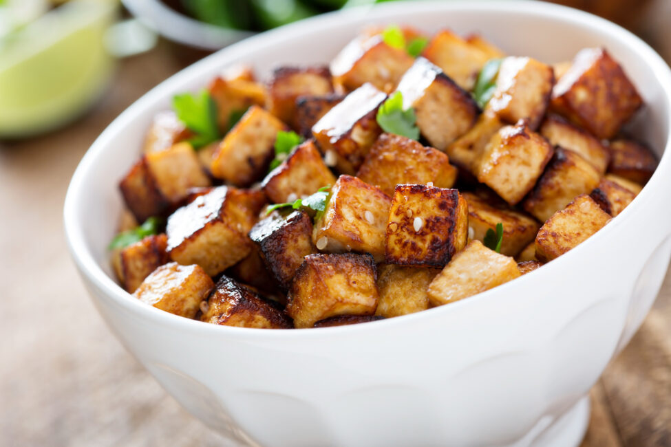 Stir fried tofu in a bowl with sesame and greens