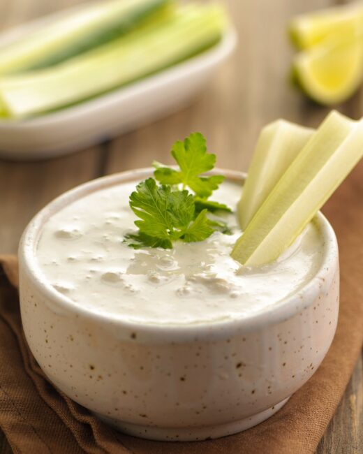 Easy Blue Cheese Dressing with celery, fresh herbs and on a wooden background