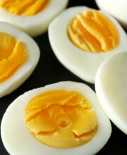 Sliced hard boiled eggs on black background. Nutrition concept