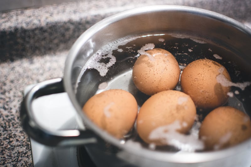 hard boiled eggs in boiling water and pot
