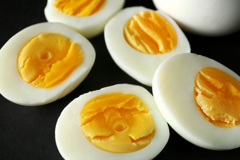 Sliced hard boiled eggs on black background. Nutrition concept