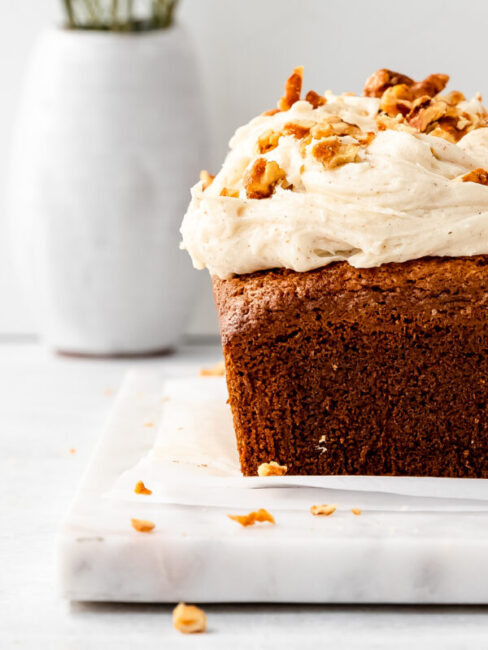 spicy chai meets sweet spring carrots in this simple and flavor packed loaf cake topped with a brown butter cream cheese frosting and candied walnuts.