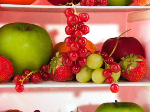 Grapes and berries in a fridge among other fruits