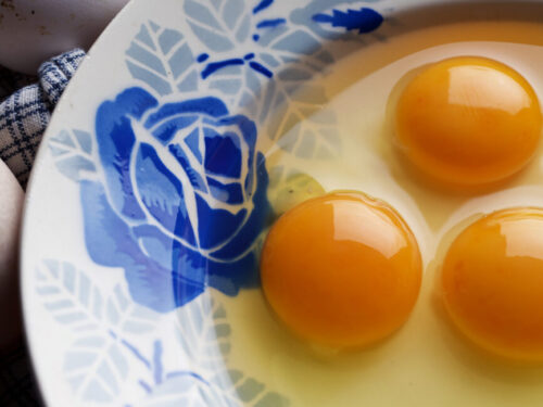 3 egg yolks in a fancy blue bowl