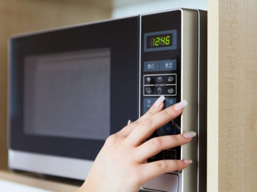 Pushing a button on the microwave.