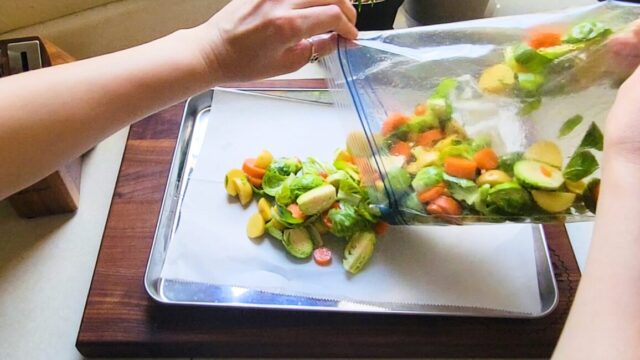 Pouring veggies onto a sheet pan