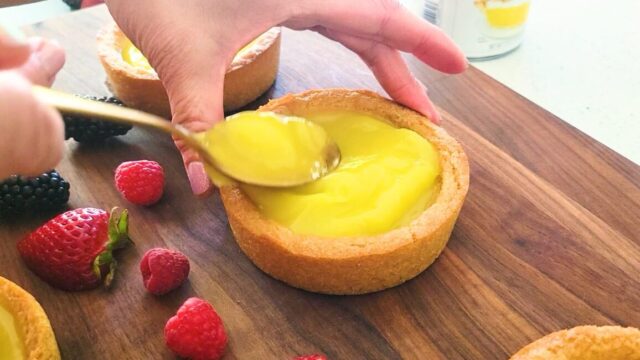 Putting lemon pie filling in a cookie tart